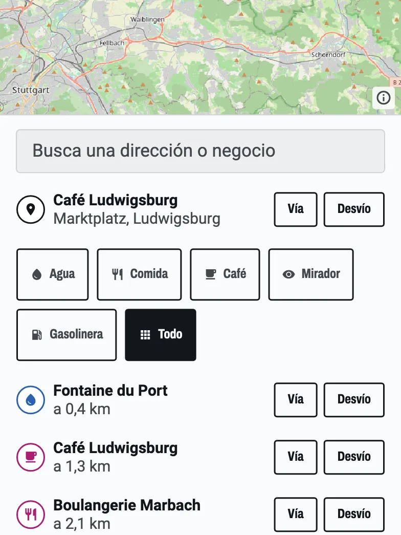 La búsqueda de paradas en la ruta: Café Ludwigsburg encontrado en la Marktplatz y una lista de paradas cercanas, cada una con botones Vía y Desvío.